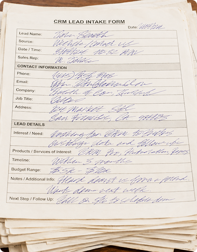 Stack of handwritten CRM lead intake forms